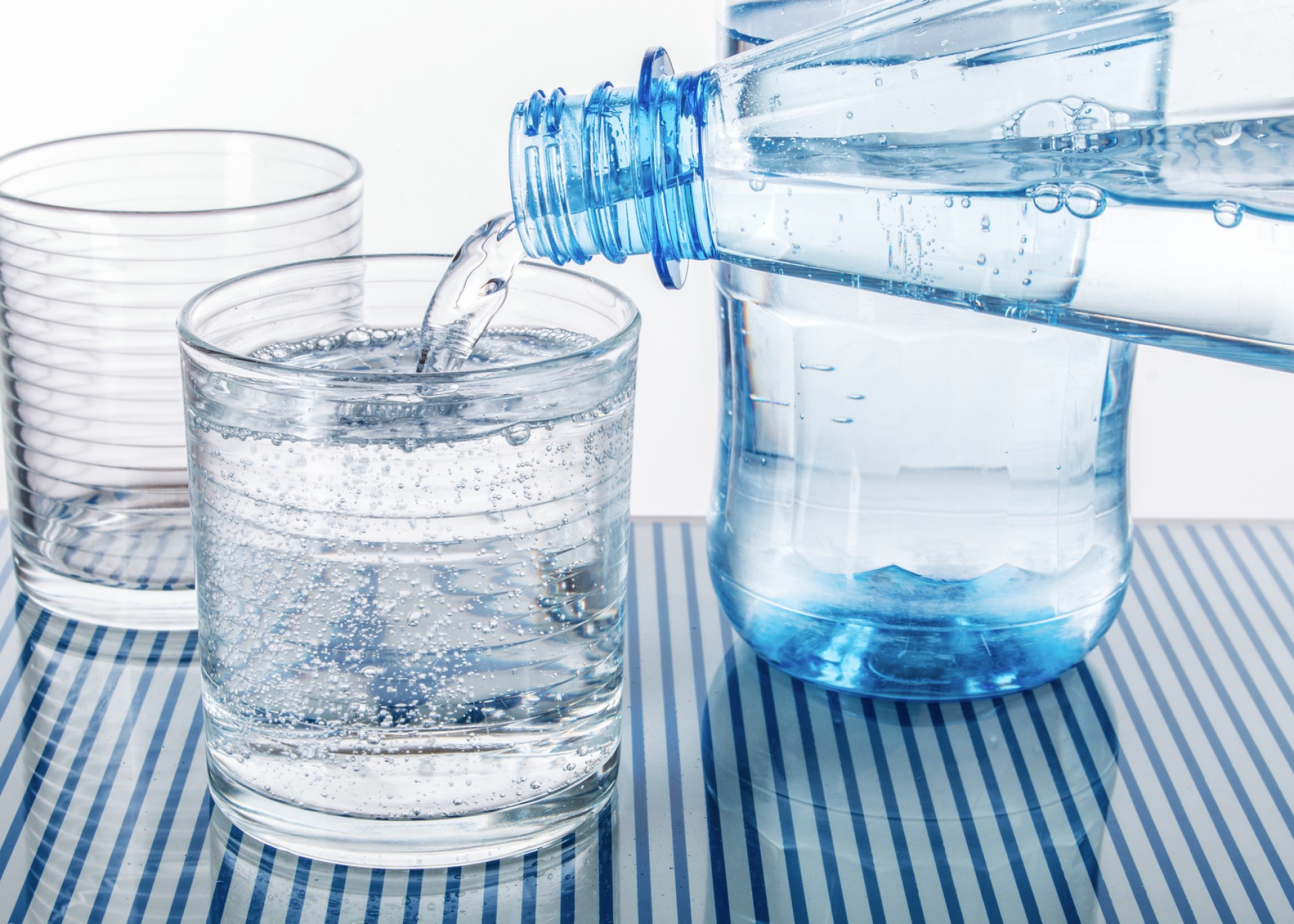 Zwei Gläser werden mit unterschiedlichem Wasser gefüllt, um die verschiedenen Anforderungen an Wasseraufbereitung zu illustrie